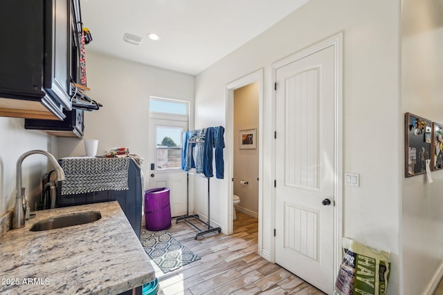 clothes washing area featuring sink and light wood-type flooring