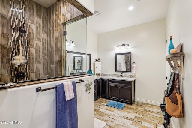 bathroom featuring vanity, hardwood / wood-style floors, and a tile shower