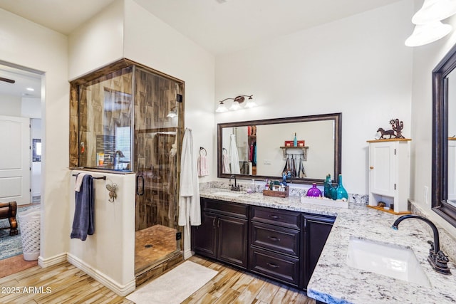 bathroom with an enclosed shower, vanity, and wood-type flooring