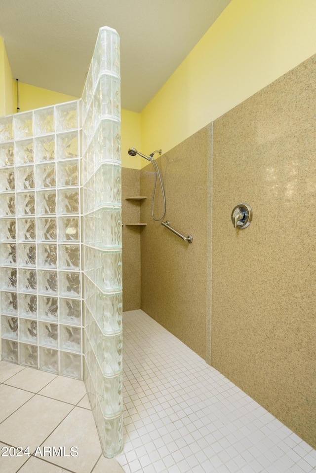 bathroom featuring tile patterned flooring and a tile shower