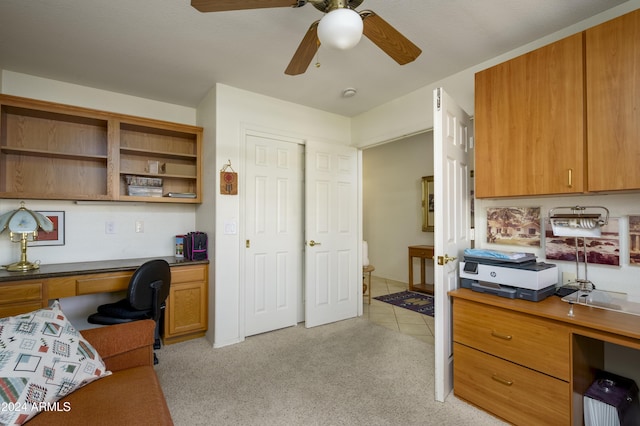 carpeted office featuring ceiling fan and built in desk