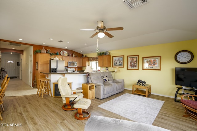 living room with ceiling fan, light wood-type flooring, and vaulted ceiling