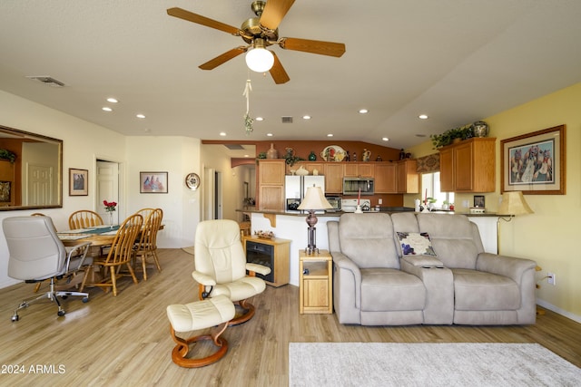 living room with light wood-type flooring, vaulted ceiling, and ceiling fan