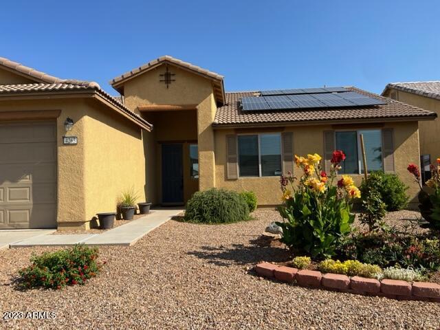 back of house featuring a garage and solar panels