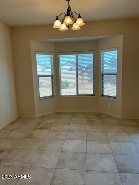 unfurnished dining area featuring a notable chandelier and light tile patterned flooring