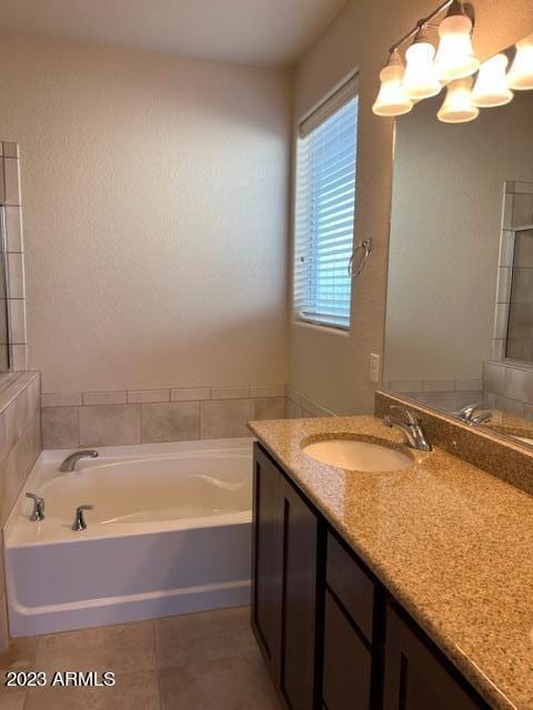 bathroom with tile patterned flooring, vanity, and a washtub