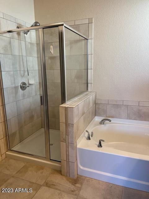 bathroom featuring tile patterned flooring and separate shower and tub