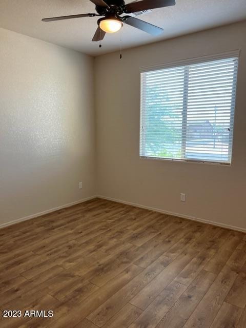 unfurnished room with dark hardwood / wood-style floors and ceiling fan