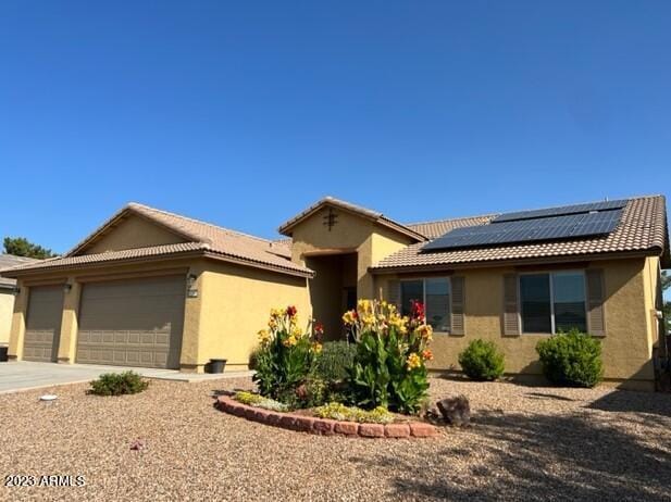 view of front of house featuring solar panels and a garage