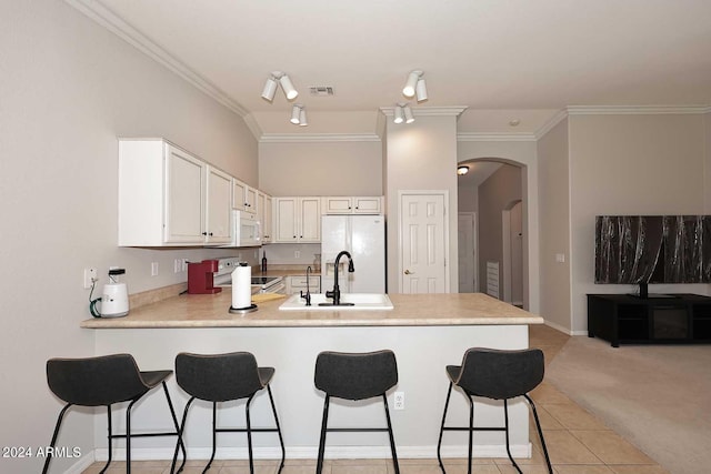 kitchen featuring white cabinetry, white appliances, kitchen peninsula, sink, and light carpet