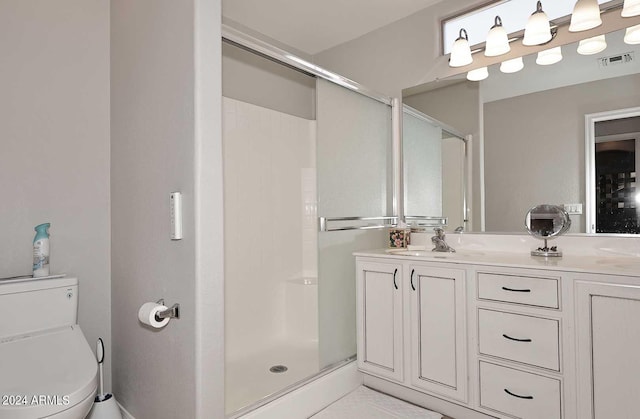 bathroom featuring vanity, toilet, and a shower with shower door