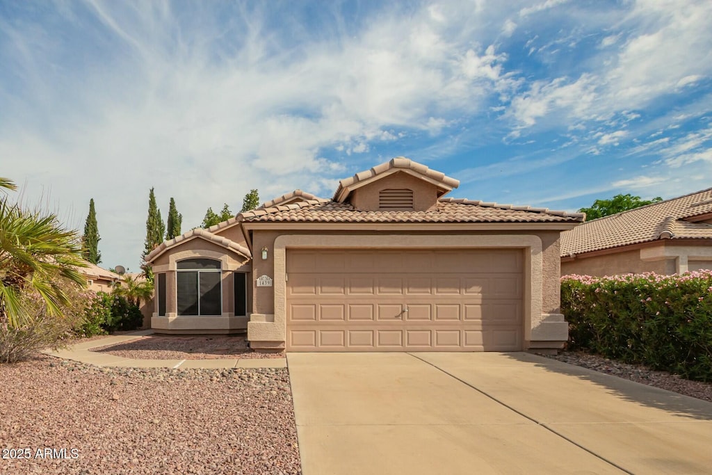 1439 S Dodge St, Gilbert, AZ 85233 - mediterranean / spanish-style home featuring a tiled roof, concrete driveway, stucco siding, and an attached garage