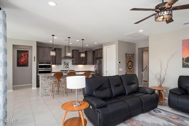 living room featuring light tile patterned floors, sink, and ceiling fan