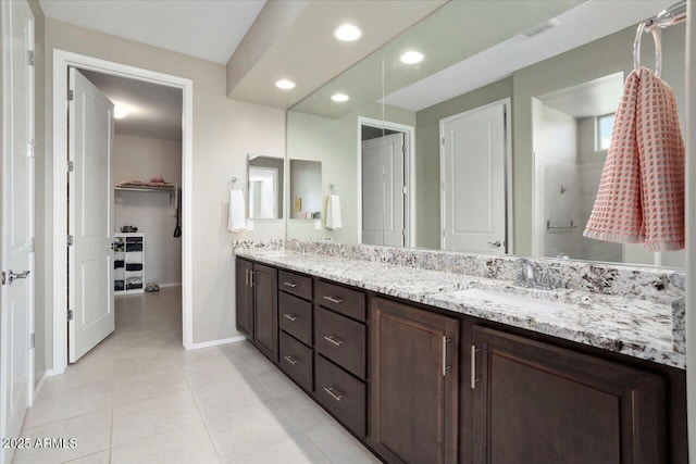 bathroom featuring tile patterned floors, vanity, and a shower