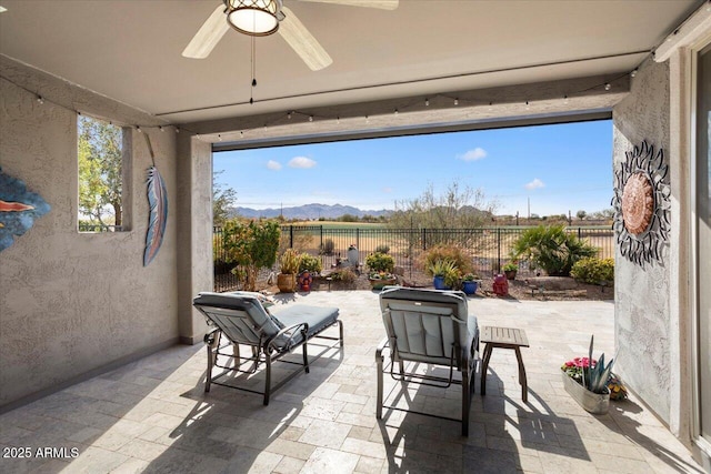 view of patio / terrace with ceiling fan and a mountain view