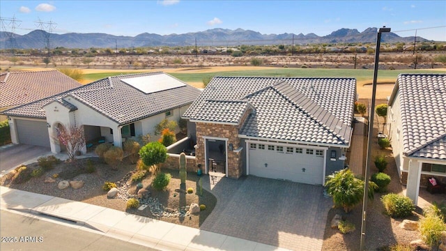 view of front of home with a garage and a mountain view