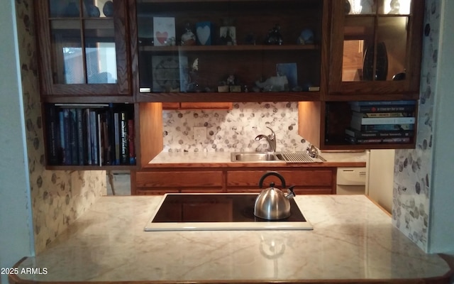 kitchen featuring light countertops, a sink, and black electric cooktop