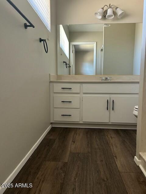 bathroom featuring vanity, wood-type flooring, and toilet