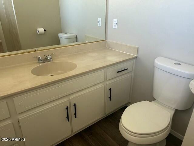 bathroom featuring vanity, hardwood / wood-style flooring, and toilet