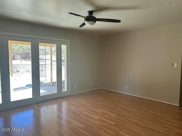 spare room featuring wood-type flooring, french doors, and ceiling fan