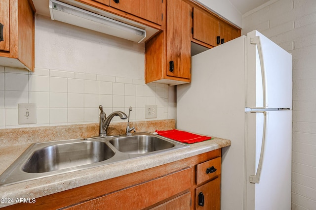 kitchen featuring tasteful backsplash, sink, and white refrigerator