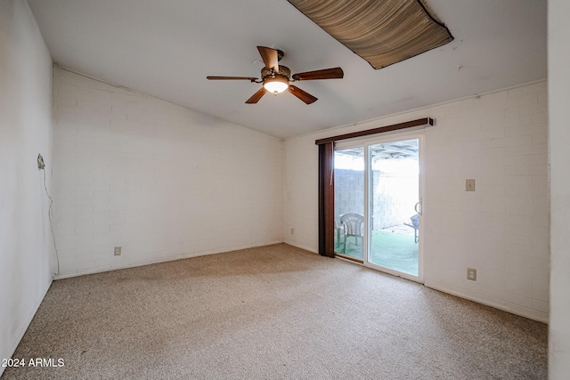 spare room featuring ceiling fan, lofted ceiling, light carpet, and brick wall