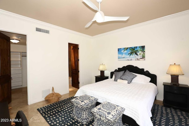 bedroom with light tile patterned floors, ceiling fan, ornamental molding, a walk in closet, and a closet