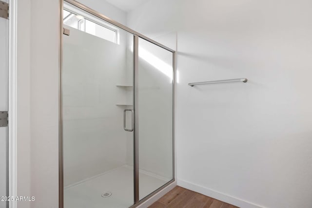 bathroom with hardwood / wood-style floors and an enclosed shower