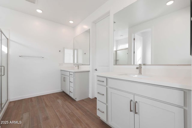 bathroom with vanity, a shower with door, and hardwood / wood-style floors