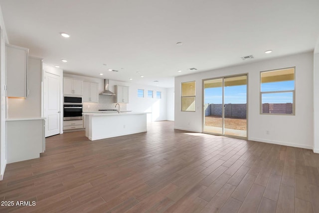 unfurnished living room with sink and hardwood / wood-style flooring