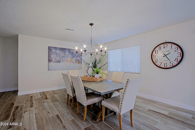 dining area with a notable chandelier and light wood-type flooring