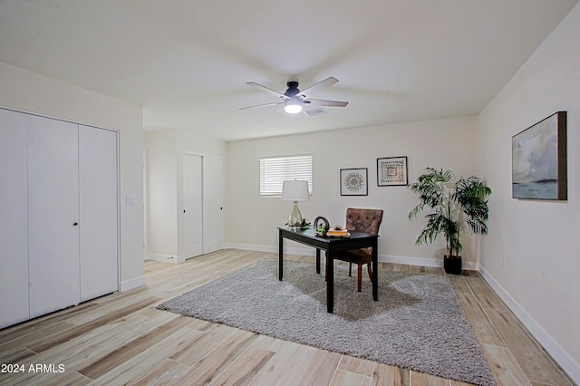 home office with ceiling fan and light hardwood / wood-style flooring