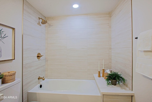 bathroom with toilet and tiled shower / bath