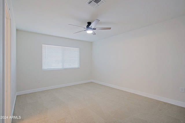 spare room featuring ceiling fan and light colored carpet