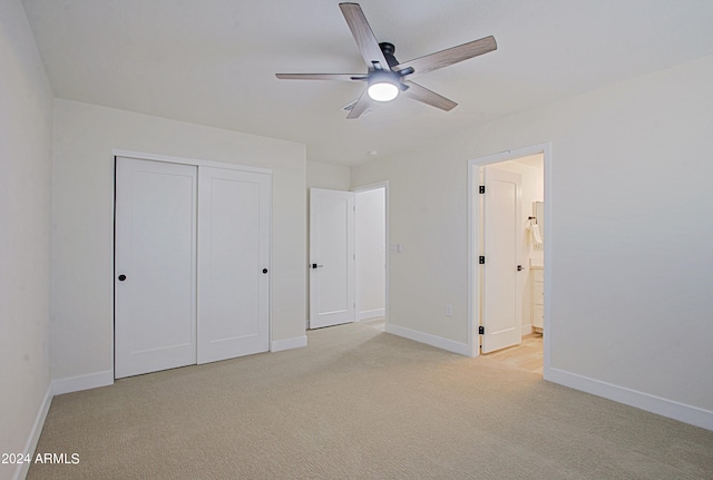 unfurnished bedroom with ensuite bath, ceiling fan, a closet, and light colored carpet