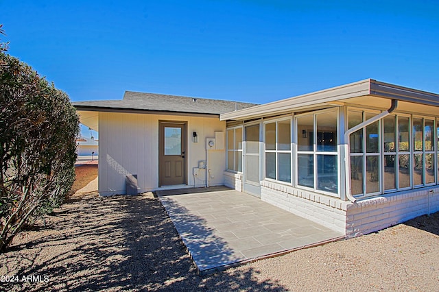 exterior space featuring a patio area and a sunroom