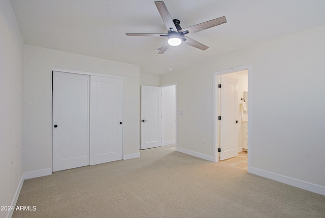 unfurnished bedroom with ceiling fan, ensuite bath, light carpet, and a closet