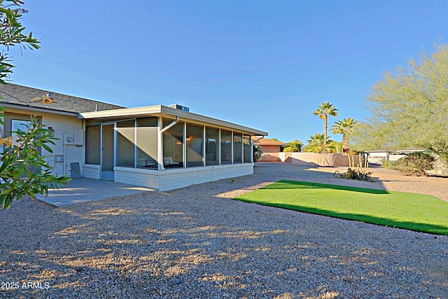 back of property with a patio area and a sunroom