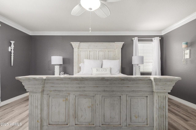 bedroom featuring crown molding, light wood-style flooring, a ceiling fan, and baseboards