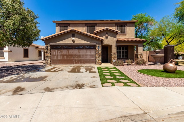 mediterranean / spanish home featuring concrete driveway, a tile roof, stone siding, stucco siding, and a garage