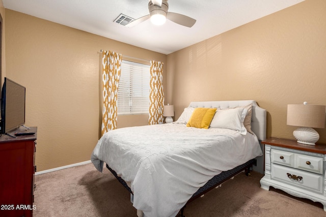 carpeted bedroom featuring a ceiling fan, visible vents, and baseboards
