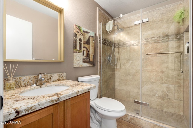 bathroom featuring toilet, vanity, and a shower stall