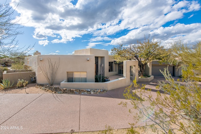 pueblo-style house featuring a garage