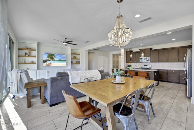 dining room featuring recessed lighting, ceiling fan with notable chandelier, built in shelves, and visible vents