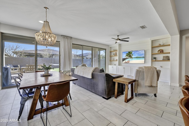 dining room featuring ceiling fan with notable chandelier, built in features, and visible vents