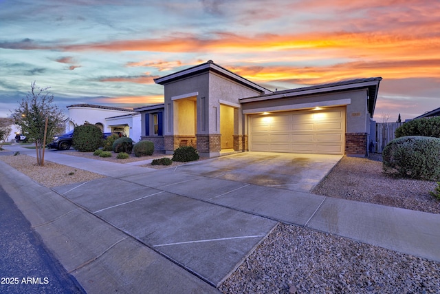 view of front facade with brick siding, concrete driveway, stucco siding, and a garage