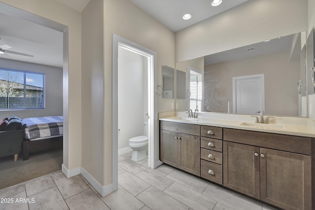 ensuite bathroom with double vanity, ensuite bath, toilet, and a sink