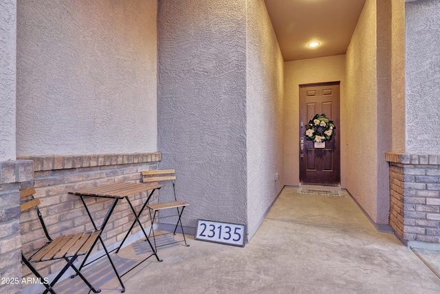 doorway to property featuring stucco siding