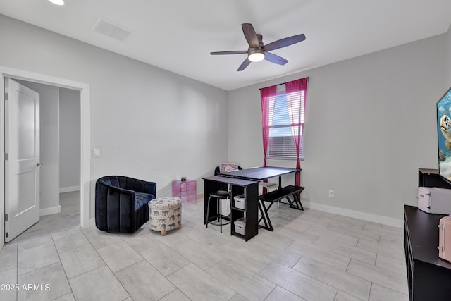 interior space with baseboards, ceiling fan, and visible vents