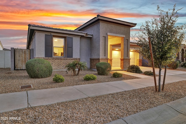 view of front of property with a tiled roof, brick siding, and stucco siding